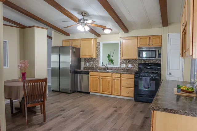a kitchen with stainless steel appliances granite countertop a stove refrigerator and cabinets