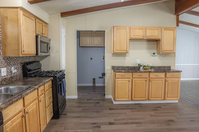 a kitchen with stainless steel appliances granite countertop a stove a sink and a microwave