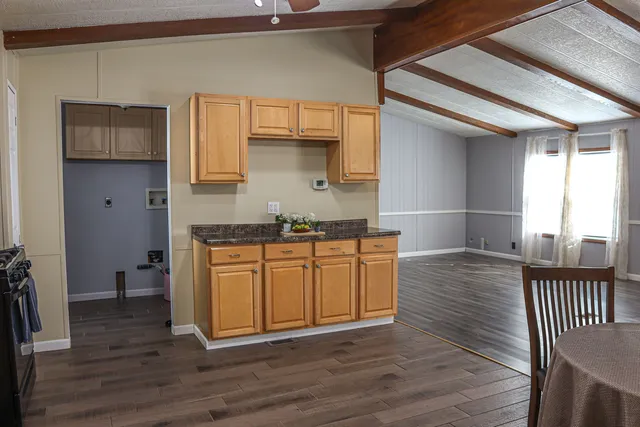 a kitchen with granite countertop a stove a sink and a refrigerator