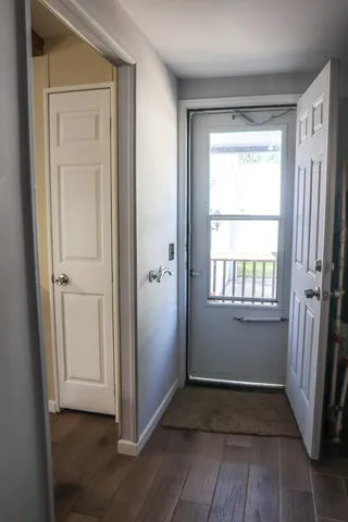 a view of an empty room with wooden floor and a window
