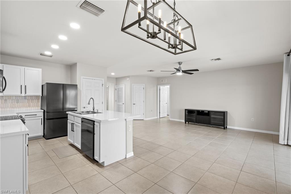 8149 Gopher Tortoise Trail Lehigh Acres, FL 33972 - Photo 16 of 50 a kitchen with stainless steel appliances a stove a sink and cabinets