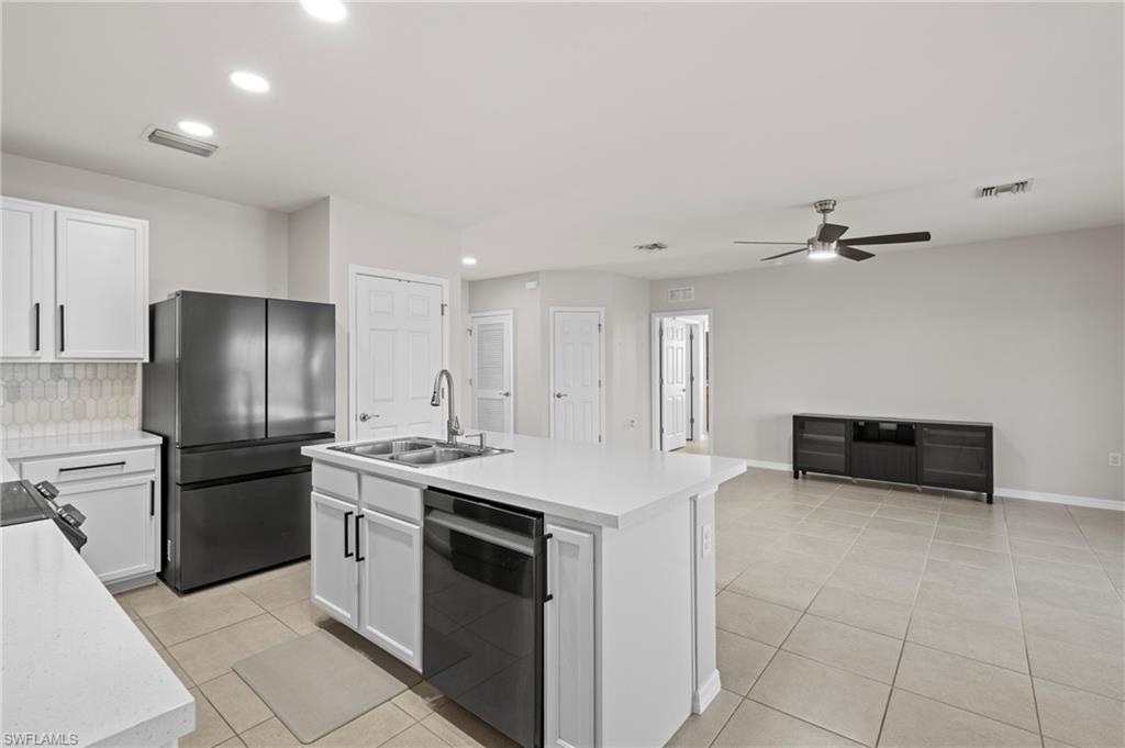 8149 Gopher Tortoise Trail Lehigh Acres, FL 33972 - Photo 22 of 50 a kitchen with stainless steel appliances a stove a refrigerator and a sink