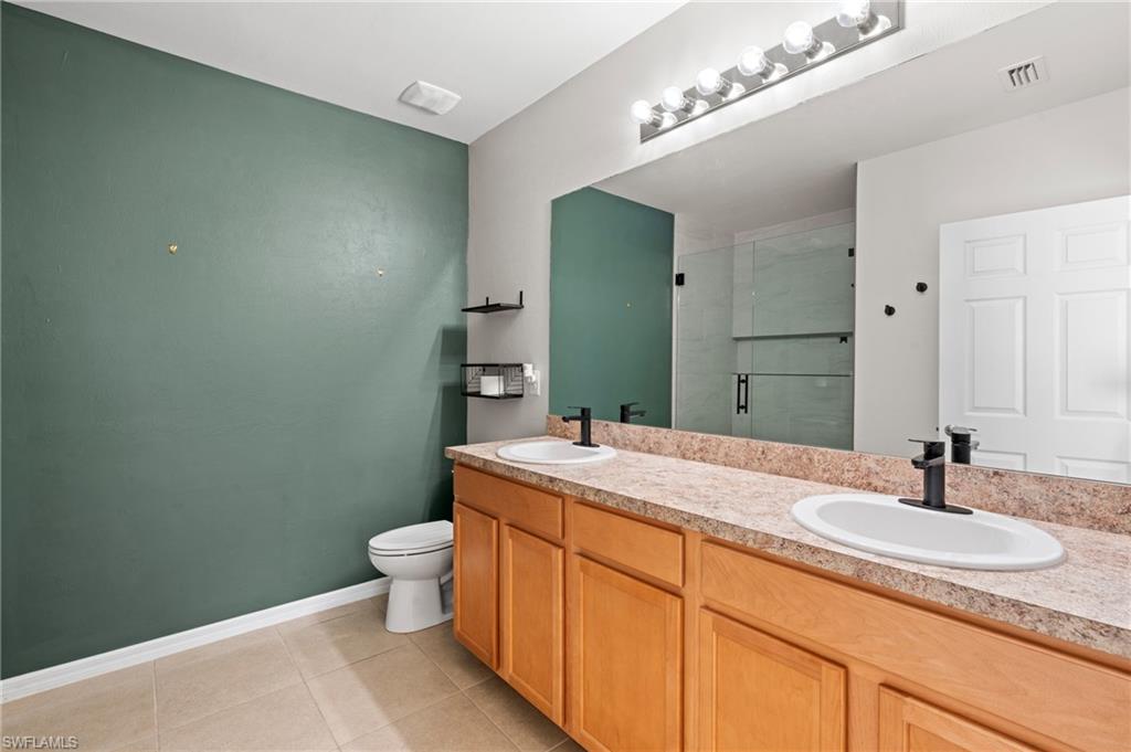 8149 Gopher Tortoise Trail Lehigh Acres, FL 33972 - Photo 29 of 50 a bathroom with a sink and mirror with toilet