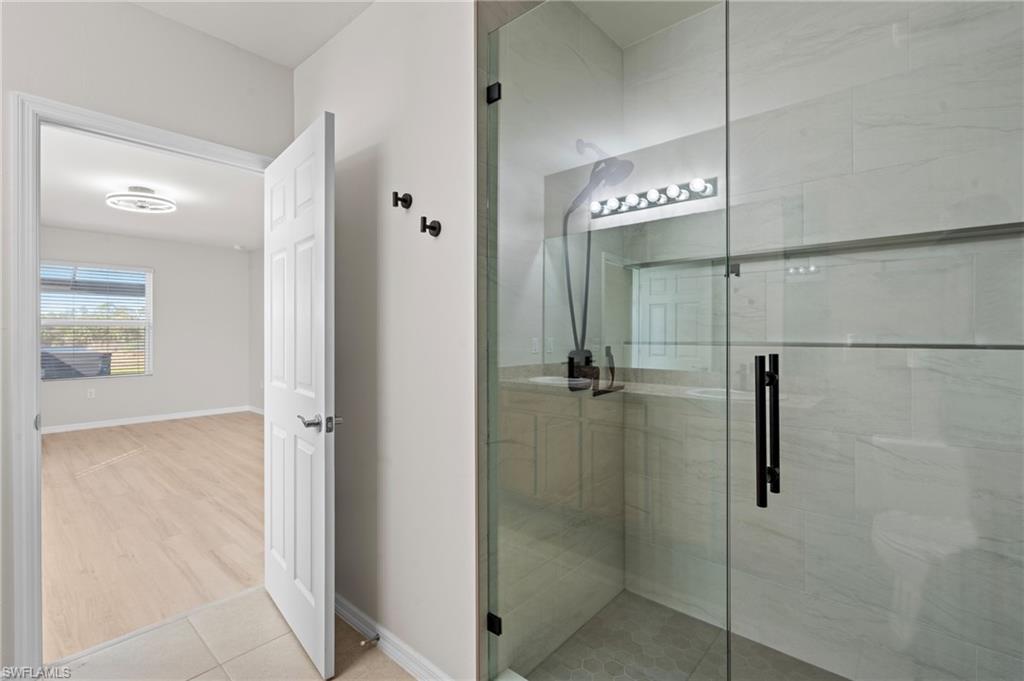 8149 Gopher Tortoise Trail Lehigh Acres, FL 33972 - Photo 30 of 50 a bathroom with a glass shower door