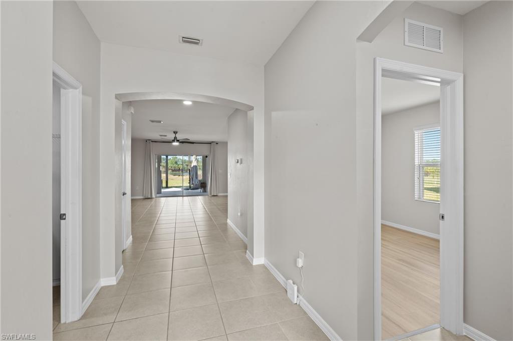 8149 Gopher Tortoise Trail Lehigh Acres, FL 33972 - Photo 32 of 50 a view of a hallway with wooden floor and a bathroom