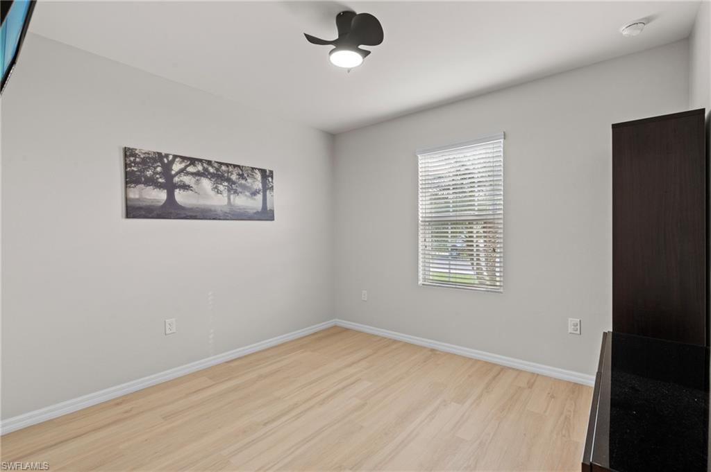 8149 Gopher Tortoise Trail Lehigh Acres, FL 33972 - Photo 33 of 50 a view of an empty room with wooden floor and a window