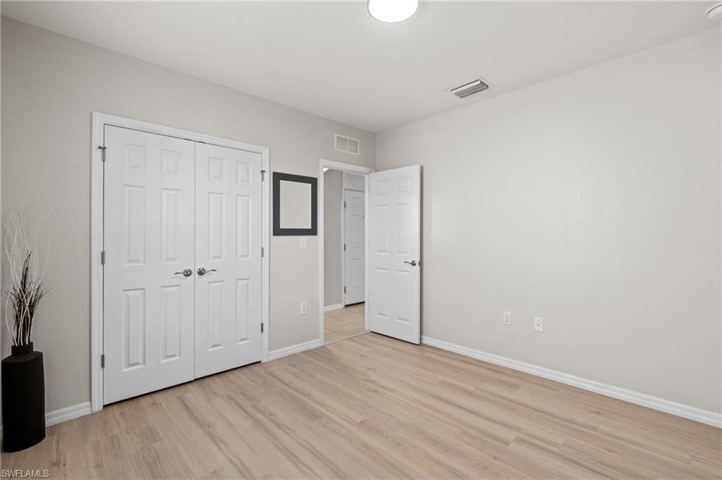 8149 Gopher Tortoise Trail Lehigh Acres, FL 33972 - Photo 35 of 50 a view of an empty room with wooden floor