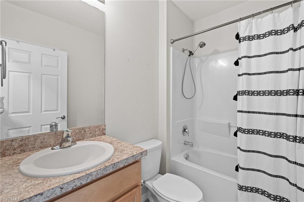 8149 Gopher Tortoise Trail Lehigh Acres, FL 33972 - Photo 36 of 50 a bathroom with a granite countertop sink toilet a shower and a bathtub