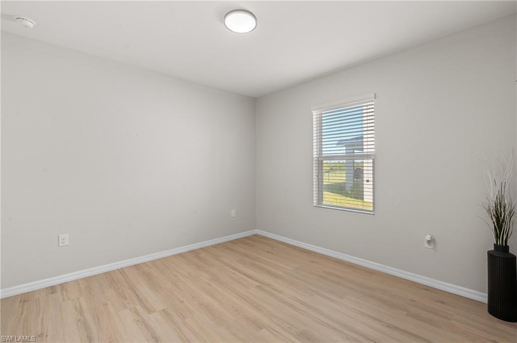 8149 Gopher Tortoise Trail Lehigh Acres, FL 33972 - Photo 37 of 50 an empty room with wooden floor and windows