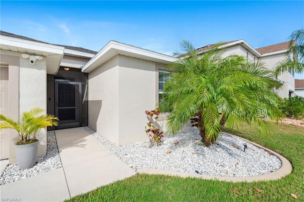 8149 Gopher Tortoise Trail Lehigh Acres, FL 33972 - Photo 5 of 50 a front view of a house with a yard