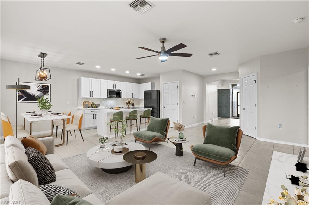 8149 Gopher Tortoise Trail Lehigh Acres, FL 33972 - Photo 6 of 50 a living room with furniture kitchen view and a chandelier