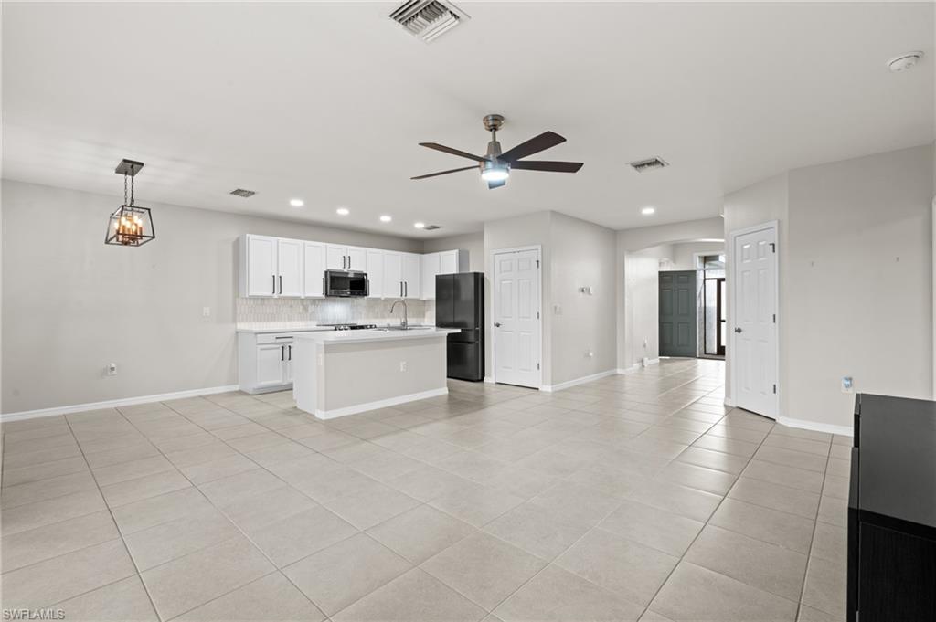 8149 Gopher Tortoise Trail Lehigh Acres, FL 33972 - Photo 7 of 50 a view of a kitchen with a sink and stainless steel appliances