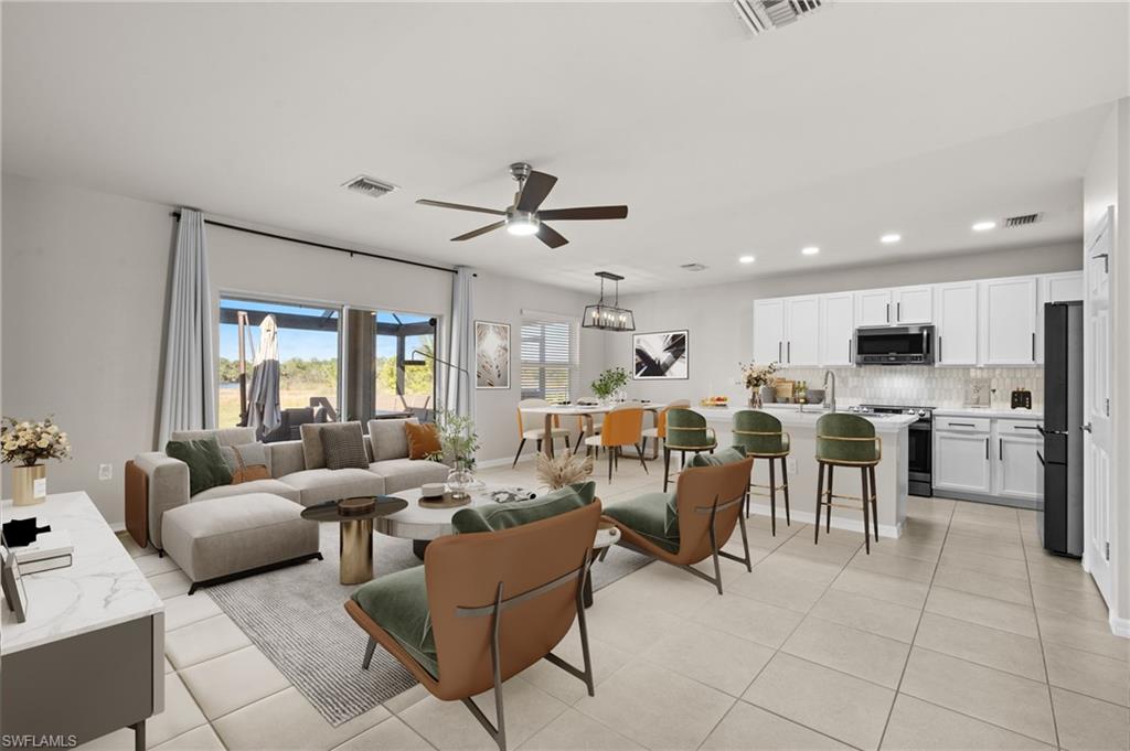 8149 Gopher Tortoise Trail Lehigh Acres, FL 33972 - Photo 8 of 50 a living room with lots of furniture and kitchen view