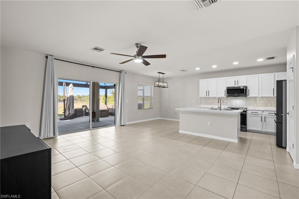 8149 Gopher Tortoise Trail Lehigh Acres, FL 33972 - Photo 9 of 50 a large kitchen with cabinets and stainless steel appliances