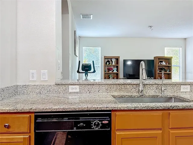a living room with furniture kitchen view and a wooden floor
