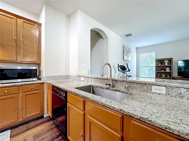 a bathroom with a granite countertop bathtub sink vanity mirror and toilet