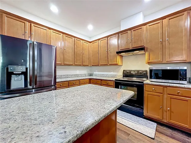 a bedroom with a large bed and wooden floor