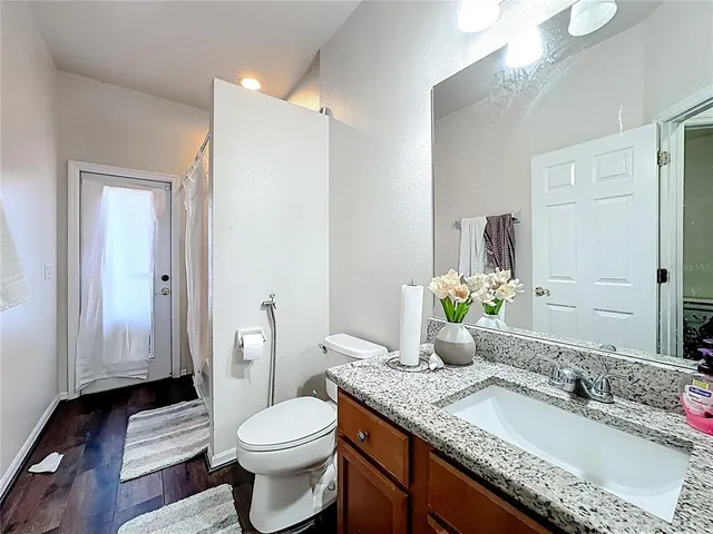 an aerial view of residential house with outdoor space and trees all around