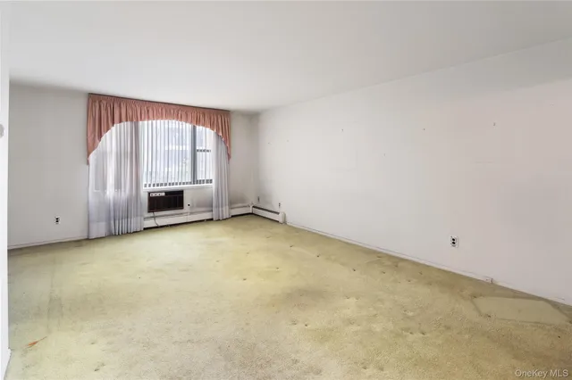an empty room with a fireplace and window