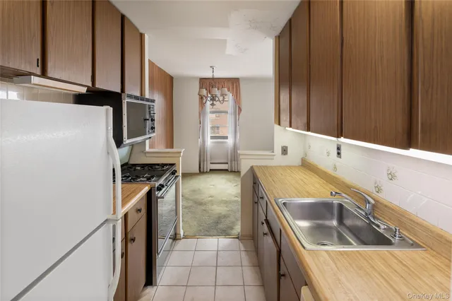a kitchen with granite countertop a sink stove and refrigerator