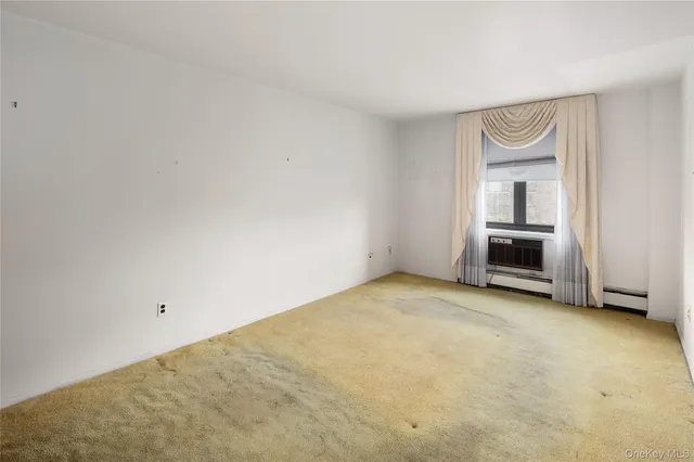 a view of an empty room with a fireplace and a window