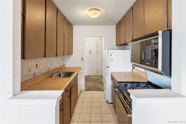 a kitchen with stainless steel appliances granite countertop a stove a refrigerator and a sink