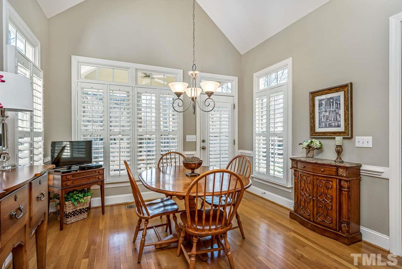7913 Pine Timber Drive Raleigh, NC 27613 - Photo 11 of 25 a view of a dining room with furniture a chandelier and wooden floor