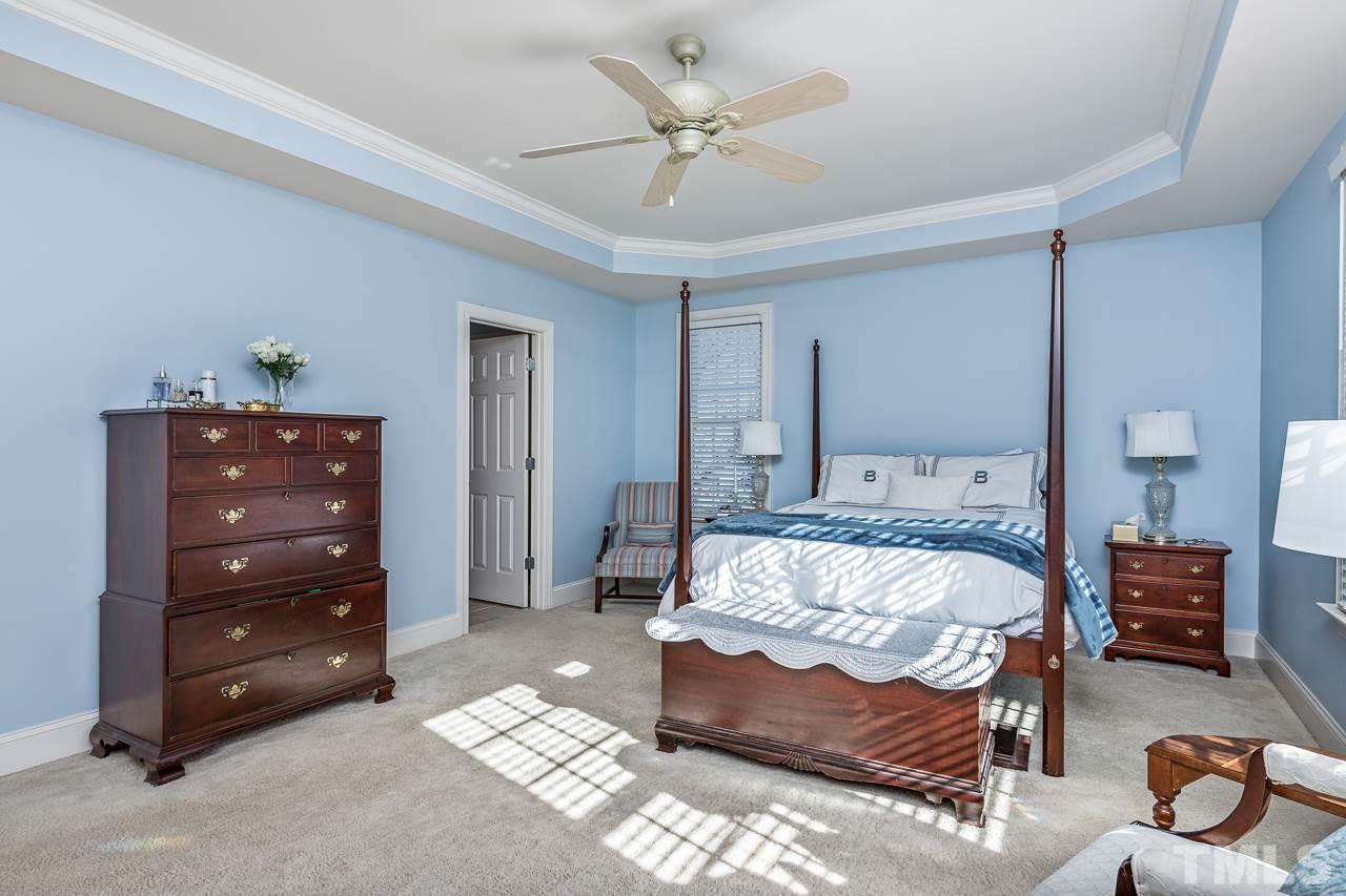 7913 Pine Timber Drive Raleigh, NC 27613 - Photo 15 of 25 a bedroom with a bed and a chandelier