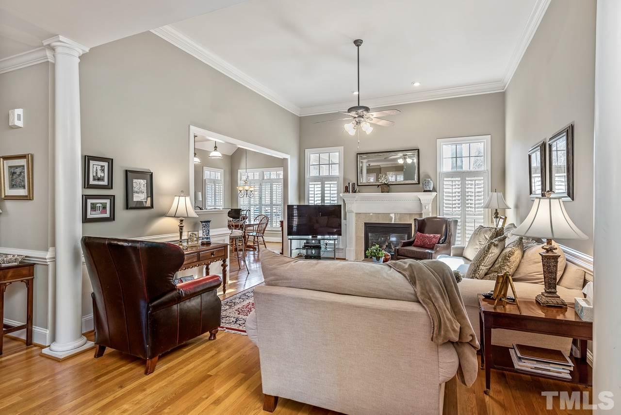 7913 Pine Timber Drive Raleigh, NC 27613 - Photo 3 of 25 a living room with furniture a fireplace and a chandelier