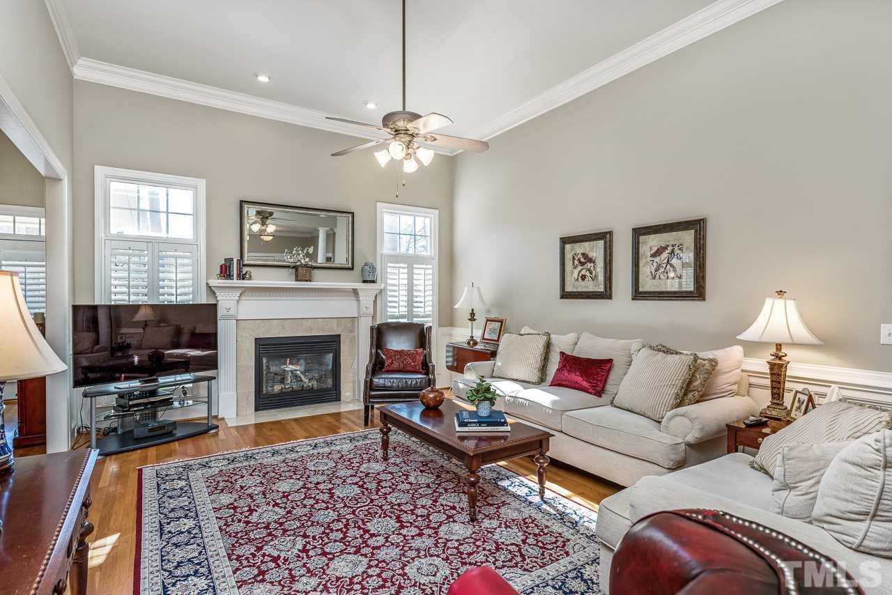 7913 Pine Timber Drive Raleigh, NC 27613 - Photo 4 of 25 a living room with furniture a fireplace and a flat screen tv