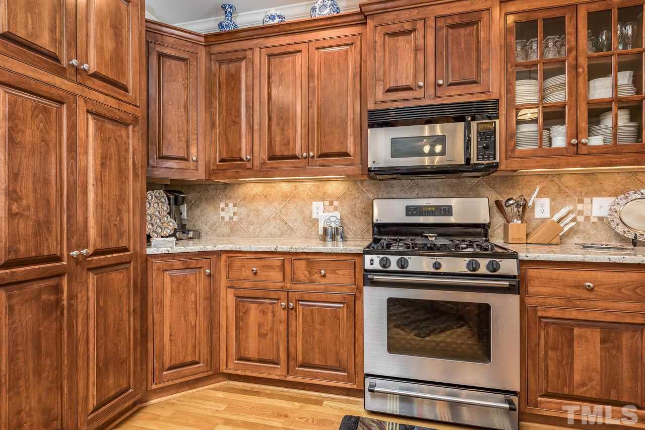 7913 Pine Timber Drive Raleigh, NC 27613 - Photo 9 of 25 a kitchen with wooden cabinets and a stove top oven