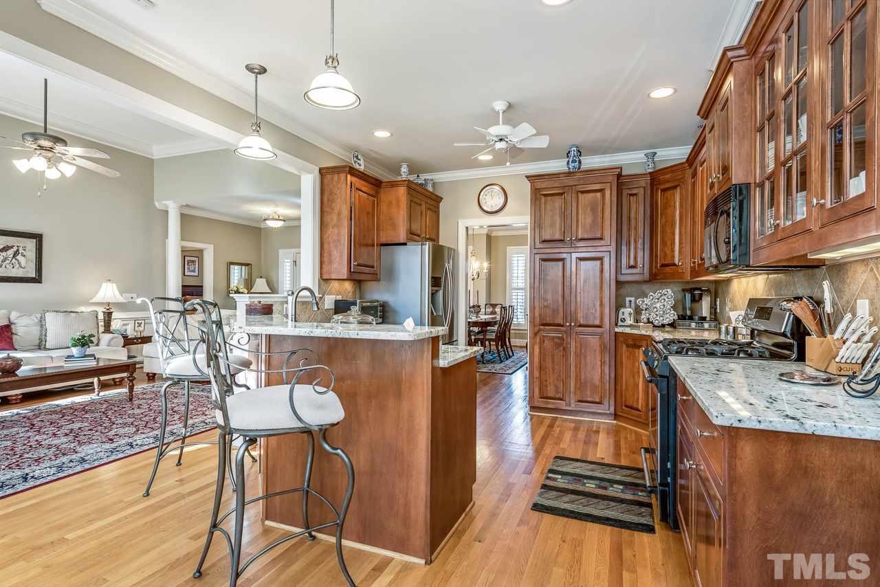 7913 Pine Timber Drive Raleigh, NC 27613 - Photo 10 of 25 a kitchen with stainless steel appliances granite countertop a refrigerator a sink dishwasher a stove and white countertops with wooden floor