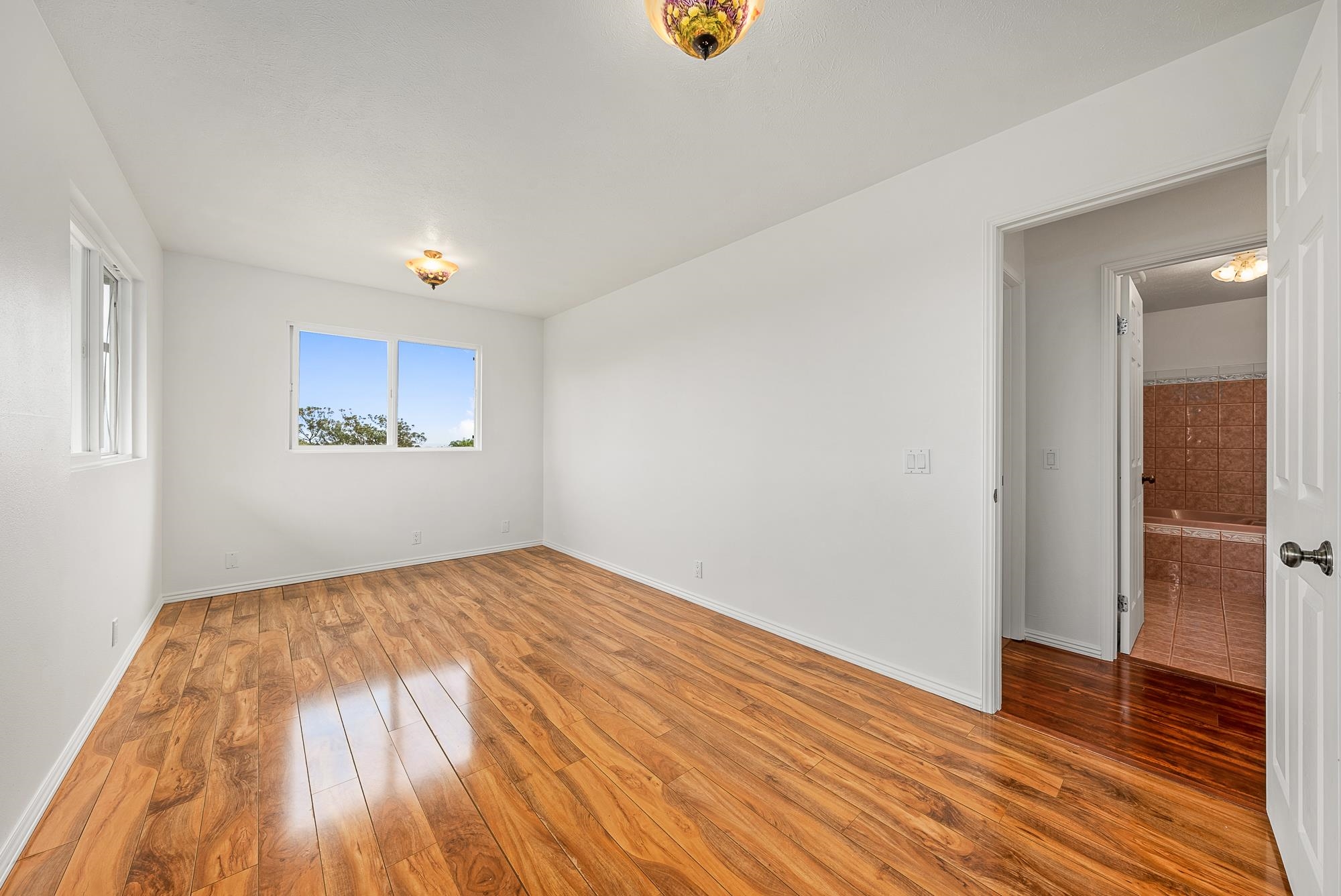 4535 Opana Place Haiku, HI 96708 - Photo 16 of 43 an empty room with wooden floor and windows
