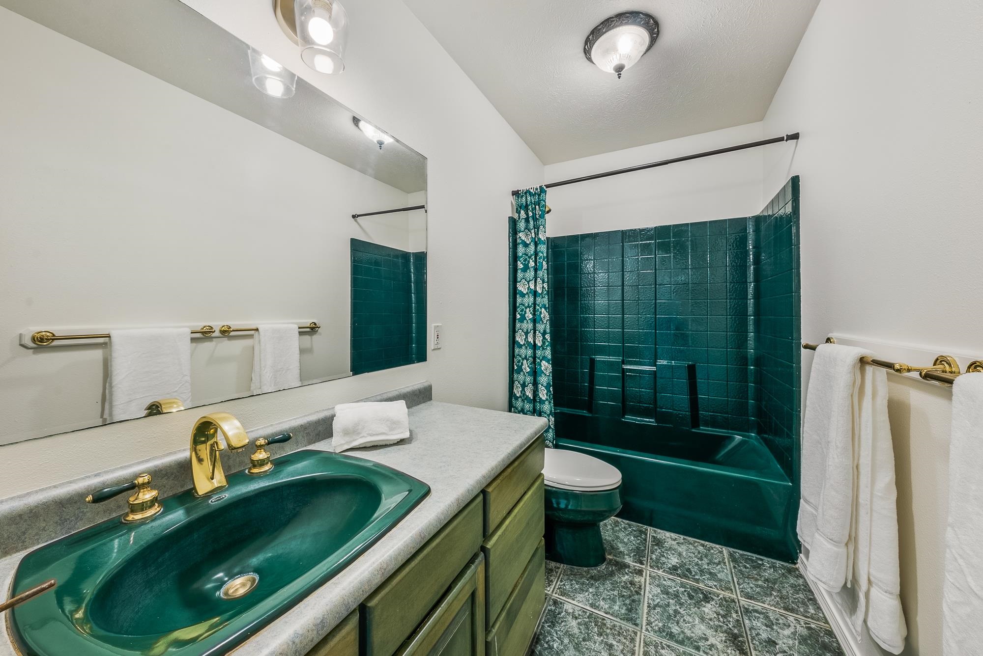 4535 Opana Place Haiku, HI 96708 - Photo 21 of 43 a bathroom with a granite countertop sink a toilet a mirror and shower