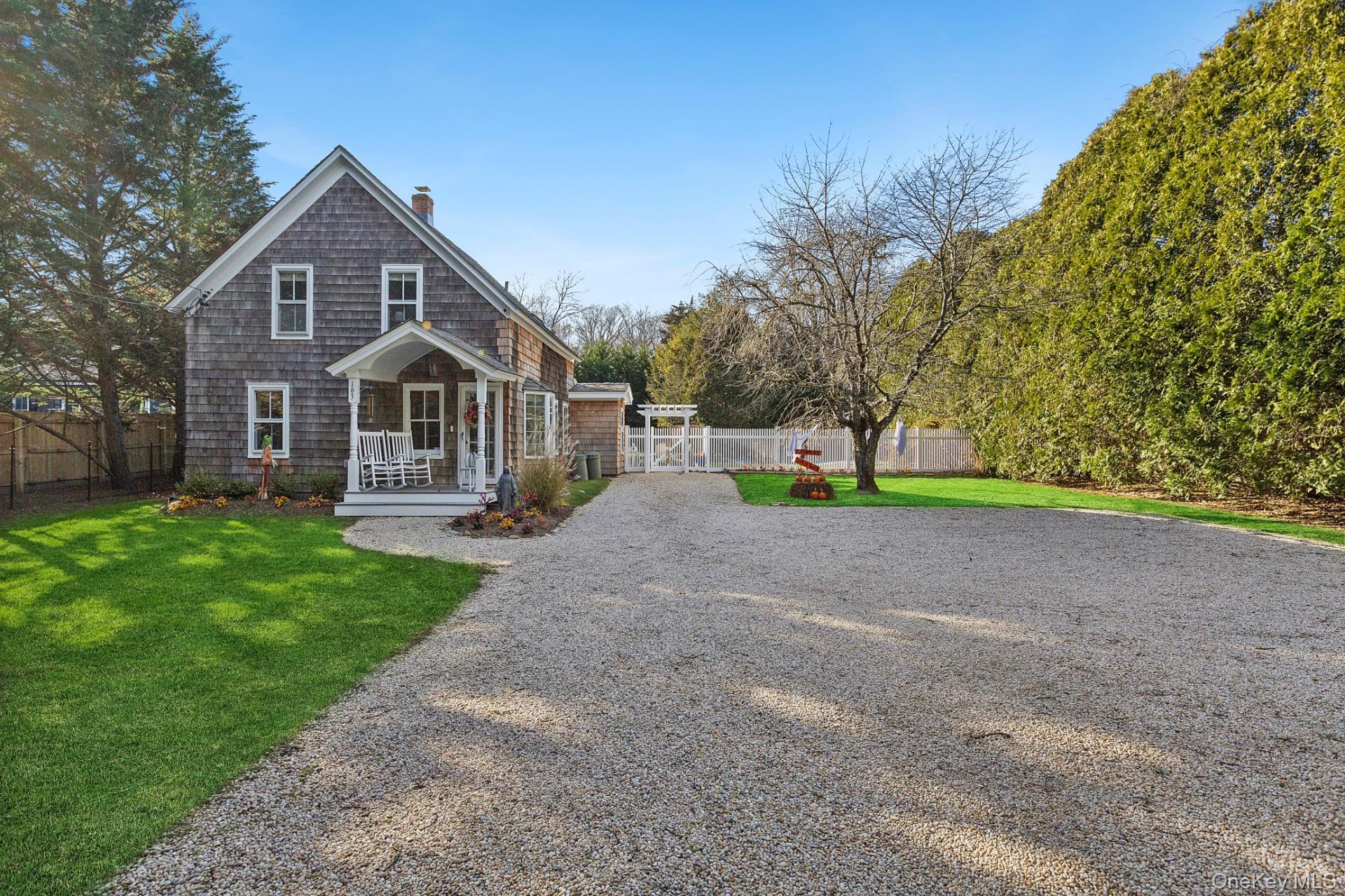 a front view of a house with a yard and trees
