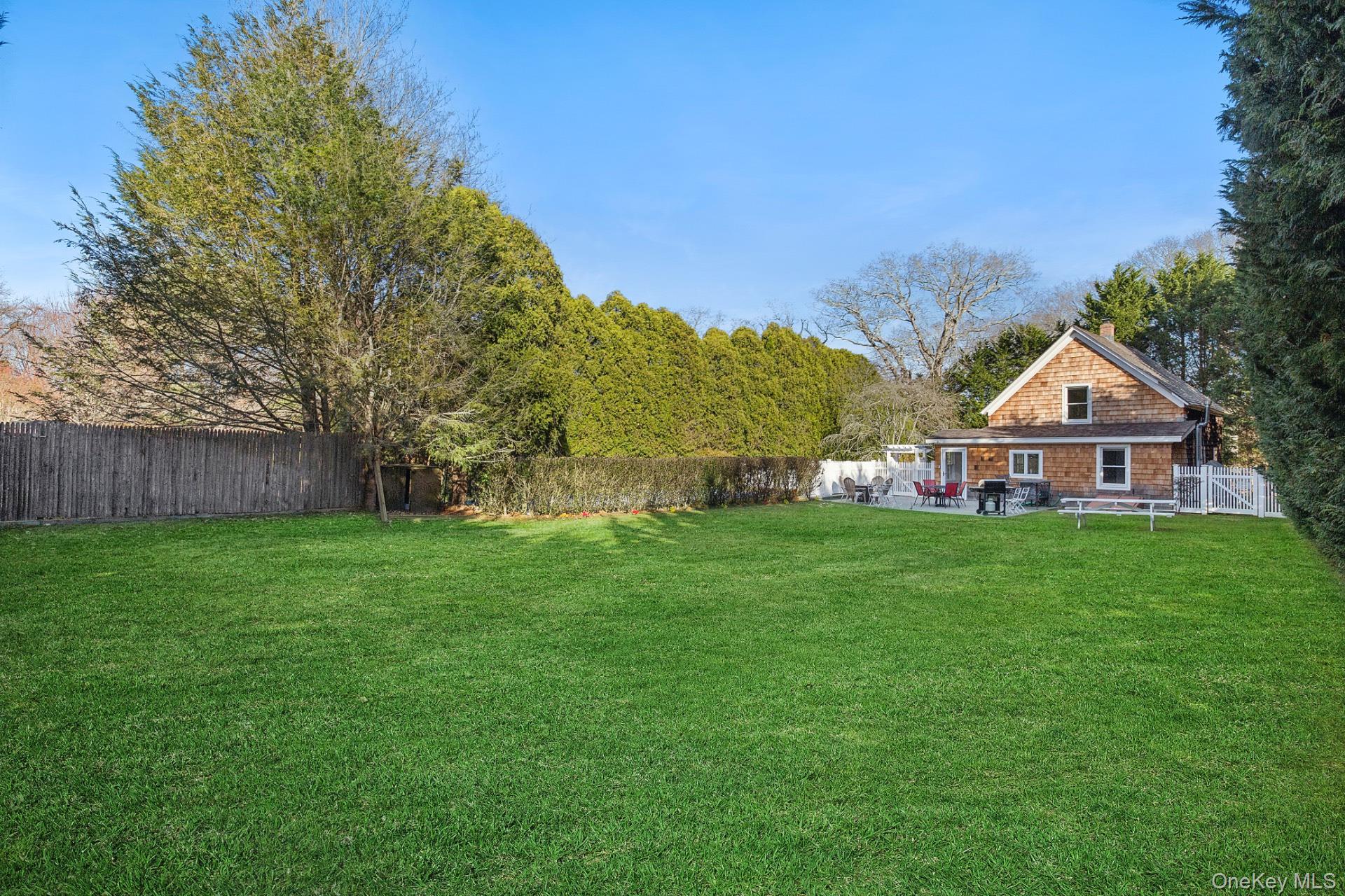 163 Three Mile Harbor Road East Hampton, NY 11937 - Photo 3 of 13 a view of a yard in front of a house with a large tree
