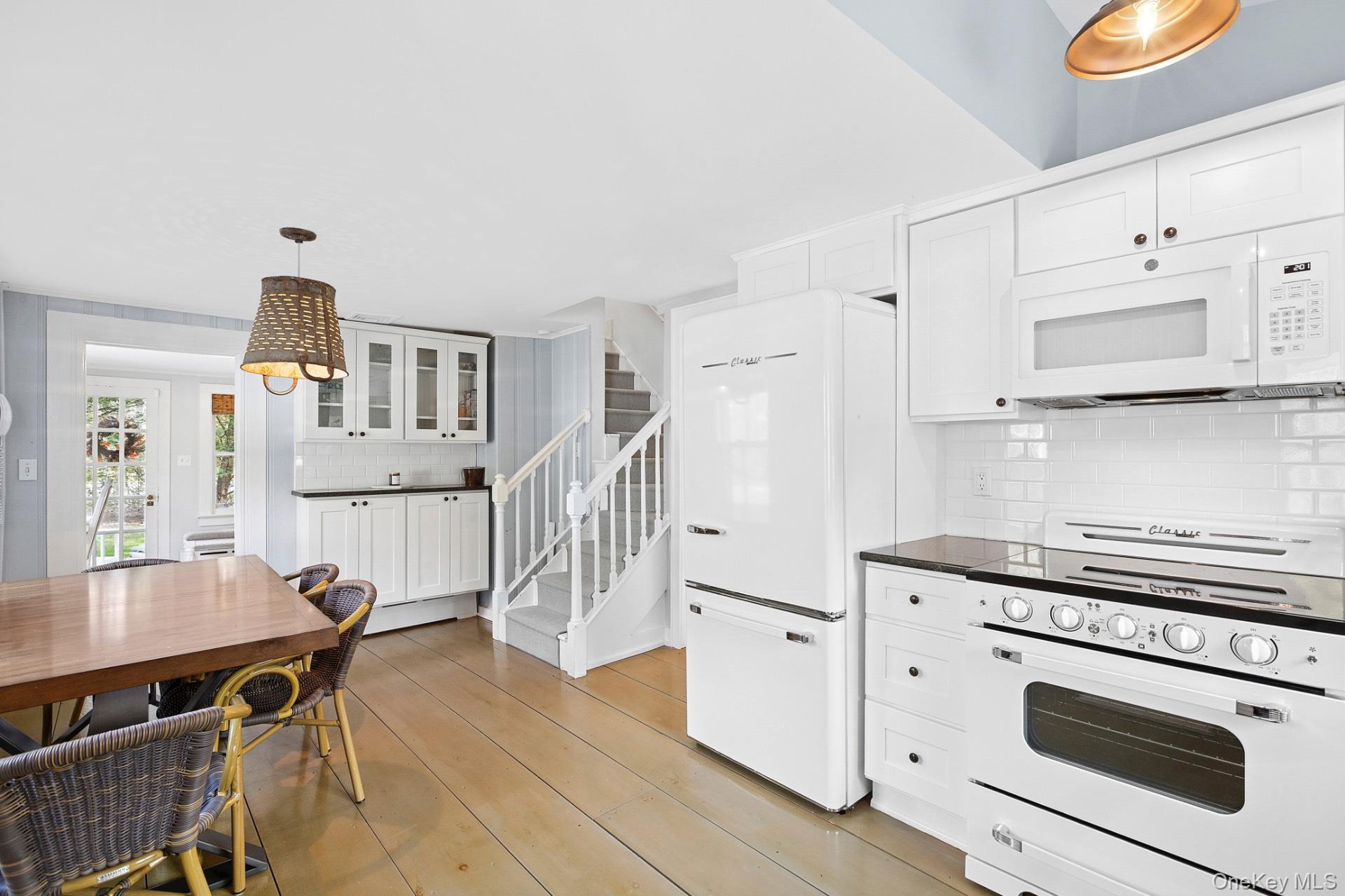 163 Three Mile Harbor Road East Hampton, NY 11937 - Photo 6 of 13 a kitchen with stainless steel appliances a stove a table and chairs