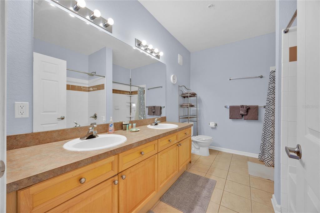 804 Terrace Ridge Circle, Unit 804 Davenport, FL 33896 - Photo 11 of 18 a spacious bathroom with a granite countertop sink a toilet a mirror and shower