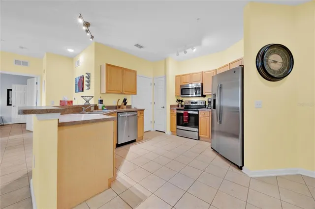 a kitchen with stainless steel appliances granite countertop a refrigerator a stove and a sink