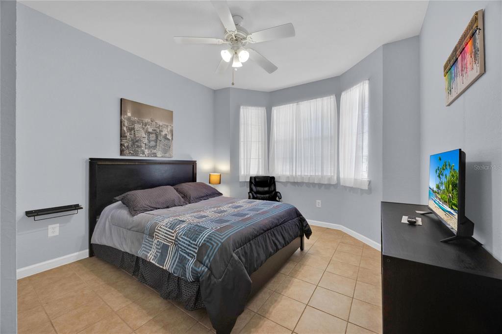 804 Terrace Ridge Circle, Unit 804 Davenport, FL 33896 - Photo 4 of 18 a bedroom with a bed and a flat tv screen on the dresser