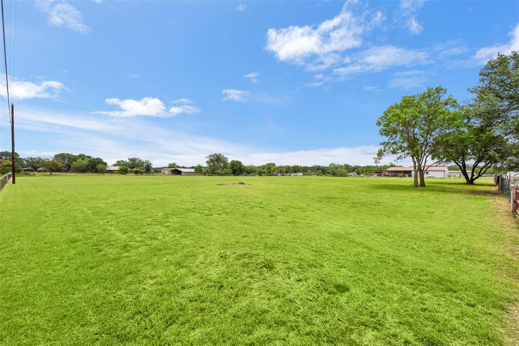 6754 Raymond Road Kaufman, TX 75142 - Photo 32 of 38 Expansive green field featuring distant structures and mature trees