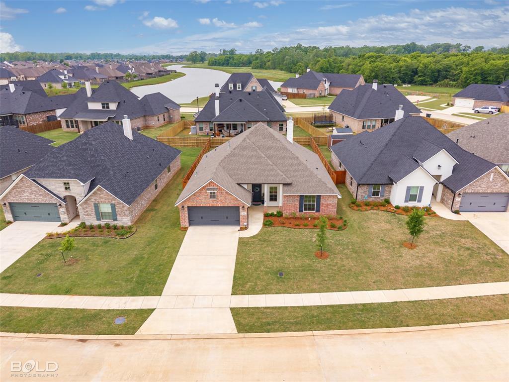 304 Prien Lk Loop Bossier City, LA 71111 - Photo 3 of 39 Brick exterior residence with a two-car garage, established front landscaping, and a concrete driveway