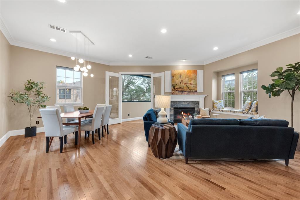 5102 Ridgedale Avenue Dallas, TX 75206 - Photo 5 of 27 Spacious living area featuring warm wood-finish flooring, a contemporary fireplace with a stone surround and white mantle, and recessed lighting