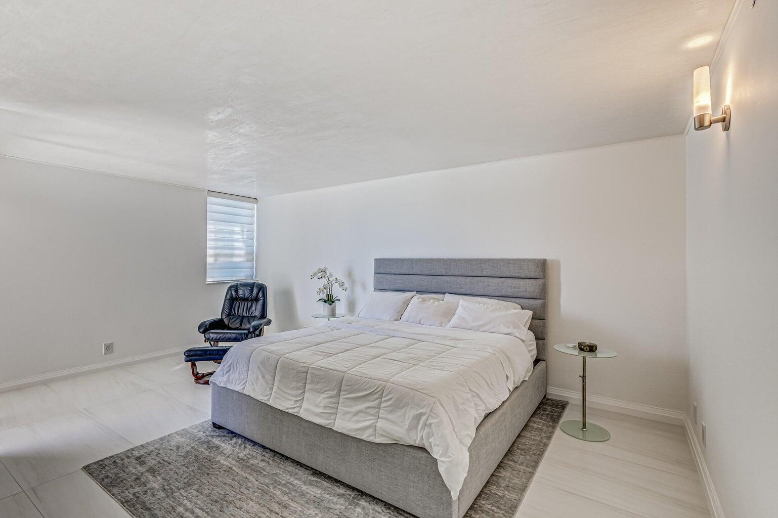 5280 North Ocean Drive, Unit 12F Singer Island, FL 33404 - Photo 23 of 66 a bedroom with a bed and wooden floor