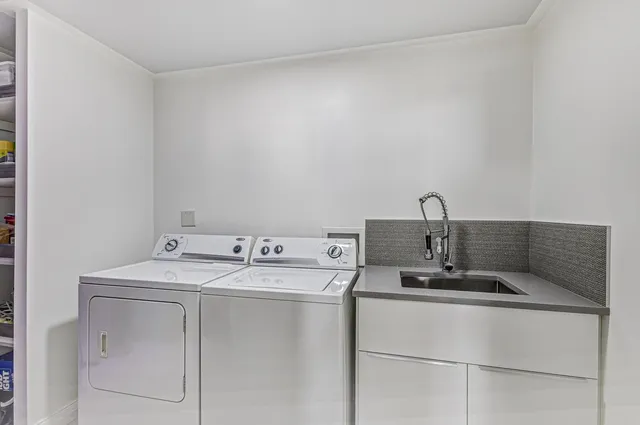 a front view of a building with a garden and plants