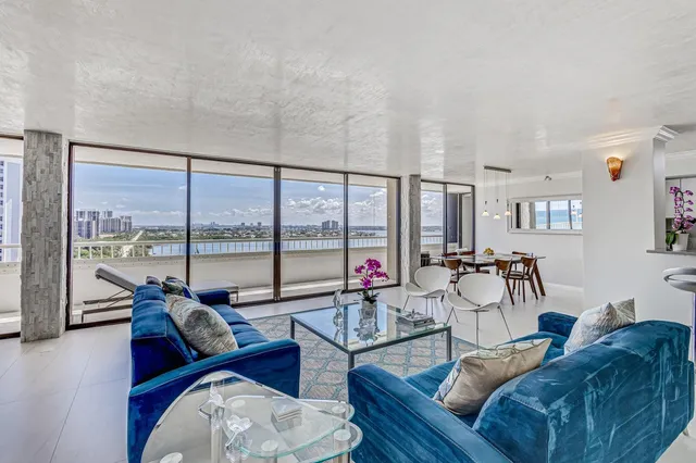 a living room with furniture and a large window with balcony view