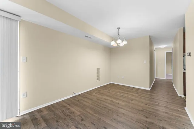 a view of a room with wooden floor and chandelier
