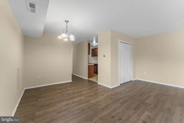 a view of a room with wooden floor and a chandelier