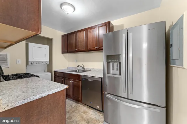 a kitchen with stainless steel appliances granite countertop a refrigerator a stove a sink and a refrigerator