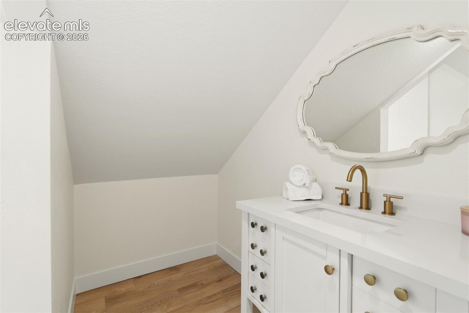 11665 Greentree Road Colorado Springs, CO 80908 - Photo 28 of 43 Bathroom featuring vanity, light wood-style floors, and vaulted ceiling